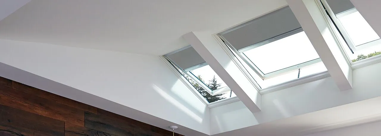 Gray blackout skylight blind installed in a bedroom